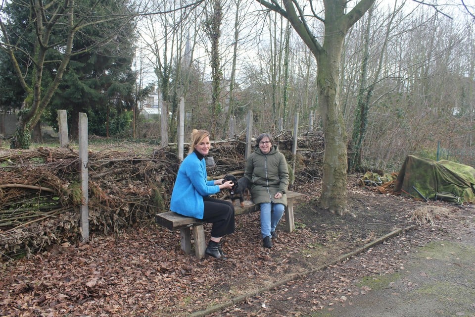 Directeur Doreen Rogiers (links) in de tuin van buurvrouw Betty Minnebo (rechts). Achter hen ligt het bosje dat de leerlingen in de toekomst mogen gebruiken.