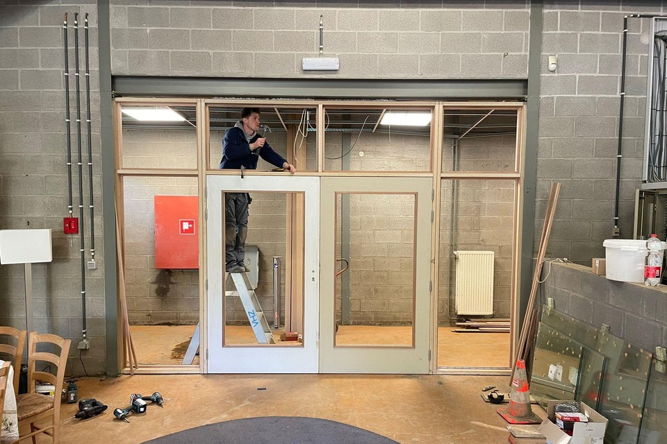 Een werknemer van Vanhout.Pro plaatst een nieuwe binnendeur in de sporthal van Prayon. 