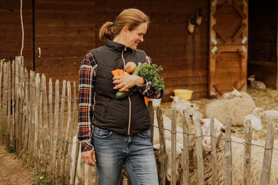Ann Kersemans uit Lille staat met een lading verse groenten bij de weide met Kempense heideschapen. 