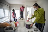 thumbnail: Waalse getroffenen van de overstromingen schilderen een woning in Turnhout die beschadigd is geraakt bij de gasontploffing op 31 december. 