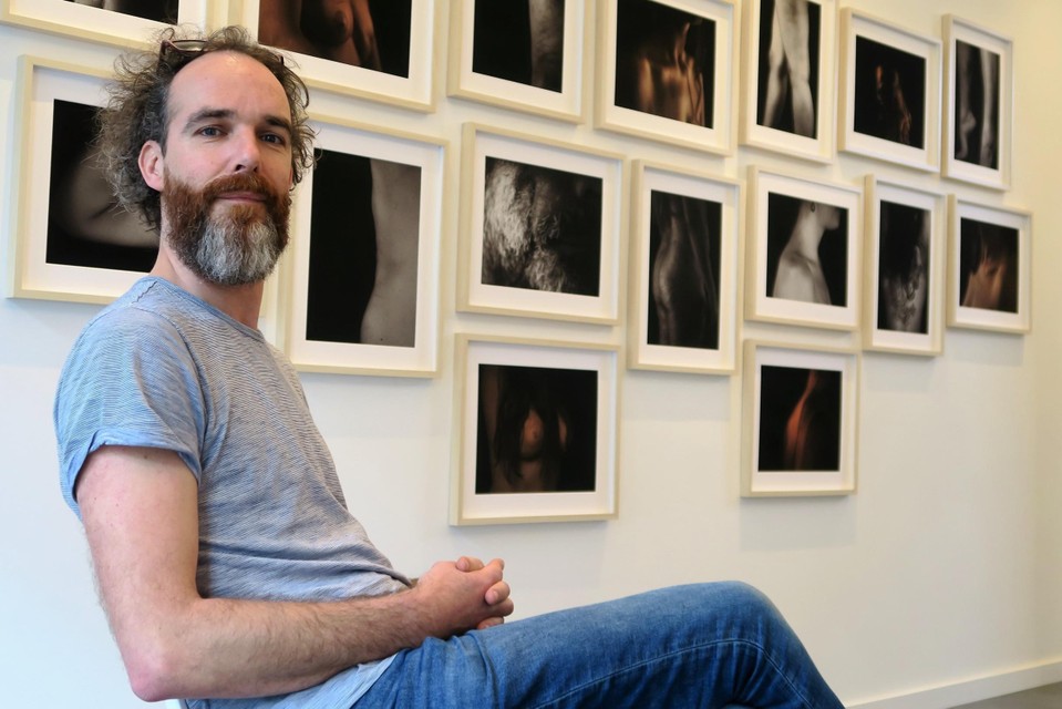Emanuel Maes in zijn eigen pop-upgalerie te midden van zijn ‘dicht op de huid’-foto’s.  