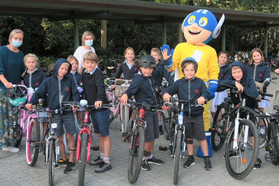 Enkelen van de intussen vele fietsende leerlingen van Sint-Ludgardis geflankeerd door directeur Anouck Verstraeten, ouder Mieke Rens en de High-Five-mascotte. 