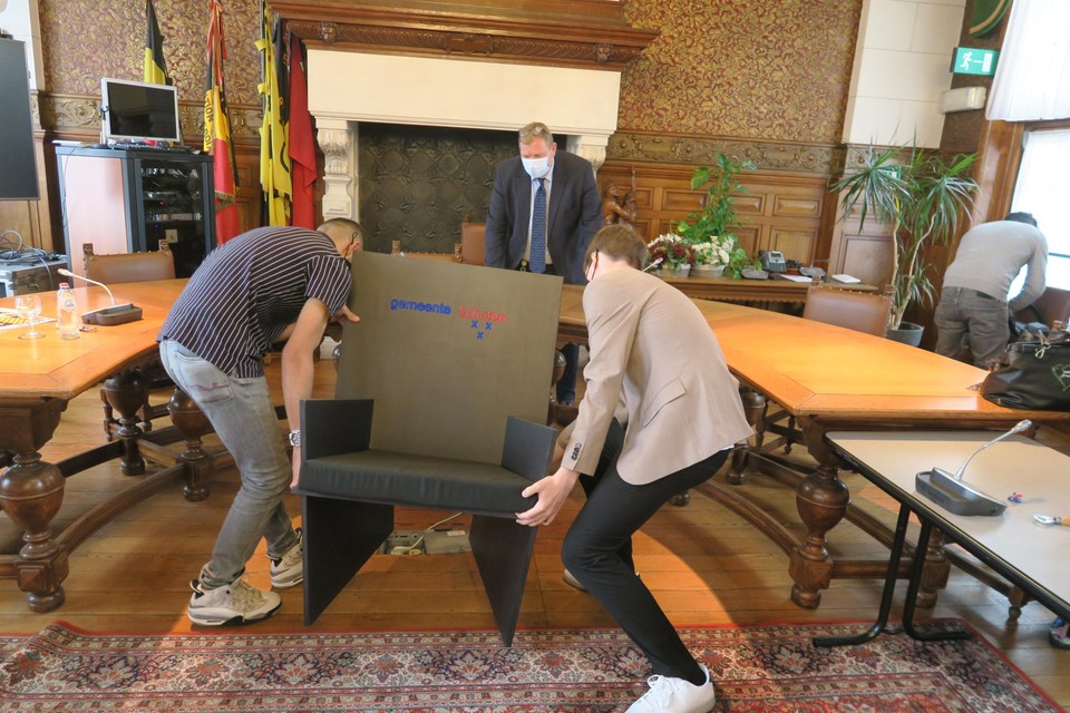 Sam en Abdul dragen de stoel van de burgemeester naar binnen.