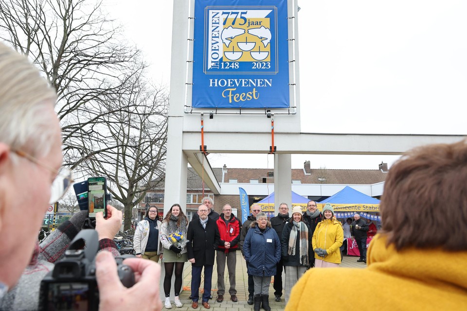 Het feestcomité stelt de verjaardagsbanner voor, samen met burgemeester Rik Frans en schepenen Jongenelen, Bardyn en Demartelaere.