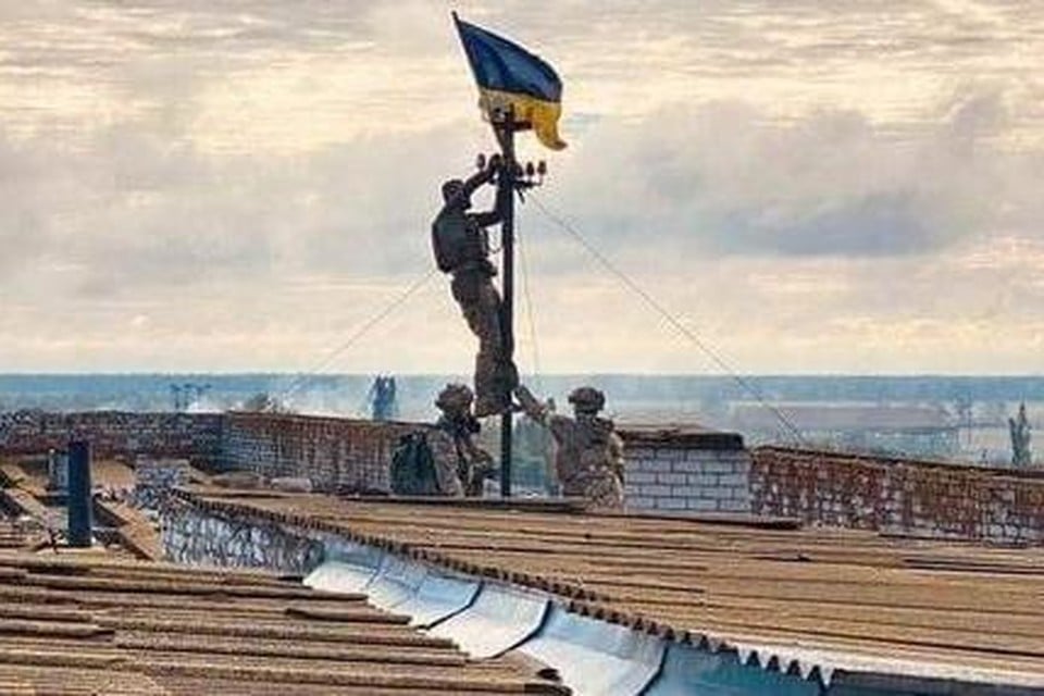 De diensten van de Oekraïense president Volodymyr Zelensky verspreidden zondag deze foto van Oekraïense soldaten die hun nationale vlag hesen boven het ziekenhuis van Visokopilia. 