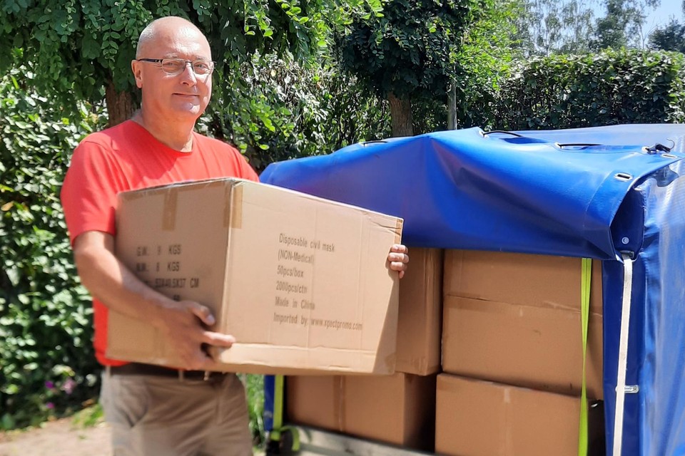 Voorzitter Patrick Geysels van vzw Warme Gloed bij de aanhangwagen vol mondmaskers voor Gambia.