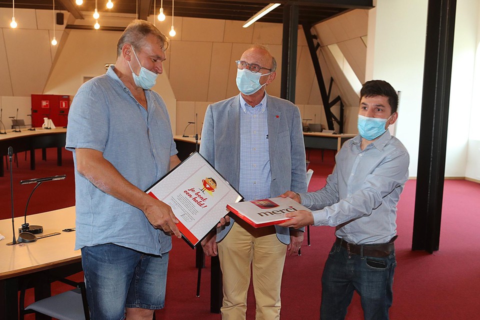 Rudy Gevaert krijgt van burgemeester Boogaerts de oorkonde en van vader Saleq Nazavy een doos bonbons.