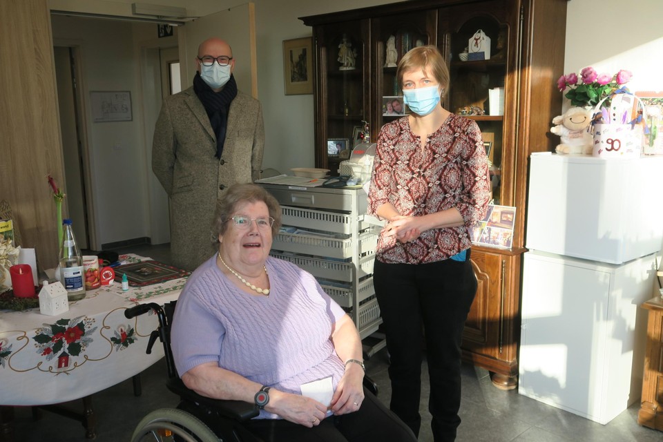 Operatie vaccinatie geslaagd. Tineke Szyr werd beschermd door haar kleindochter en coördinerend arts Anneleen Vanneuville. Burgemeester Dirk Bauwens kwam de operatie van nabij volgen.