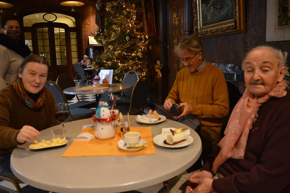 Gerda, Vic en Maurice genieten aan de kersttafel in kasteel de Renesse van een kerstpateeke en bordje kaasblokjes. 