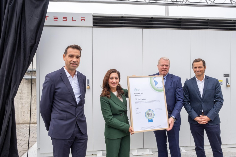 Poseren voor de Tesla-batterij: CEO Engie Benelux Thierry Saegeman, minister van Omgeving Zuhal Demir (N-VA), staan voor de nieuwe Tesla-batterij, en Antoine Geerinckx (CO2logic). 