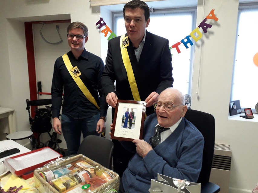 Schepenen Frans Van Looveren en Daan de Veuster (allebie CD&amp;V) overhandigden Adolf Hautman de foto van het koningspaar  op zijn honderdste verjaardag. 