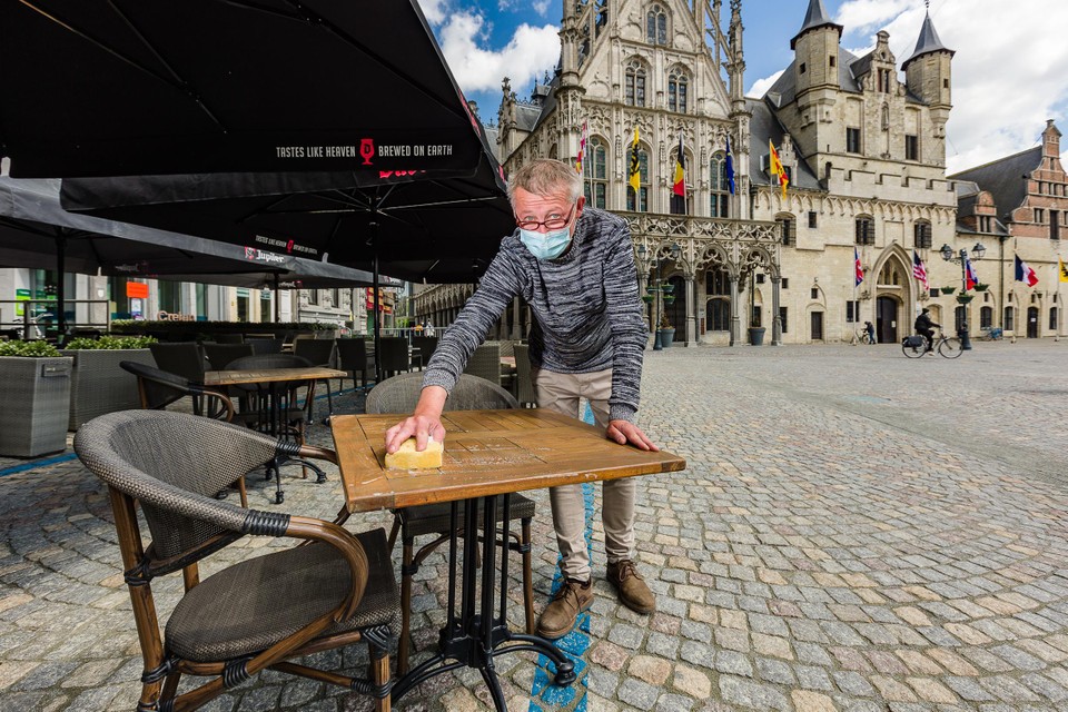 Sven Verpoucke van brasserie Oskar maakt zijn terrastafeltjes schoon. 