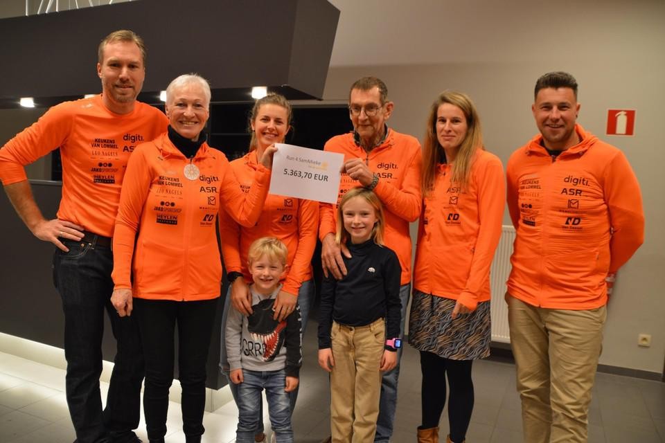 Mieke Van Hecke (tweede links) samen met nog Sam Renders (centraal) tijdens de cheque-overhandiging van de actie voor Kom op Tegen Kanker in december 2021.