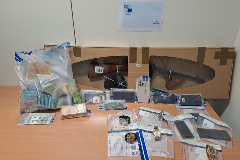 Tijdens de huiszoekingen werden meer dan 120.000 euro cash, telefoons, luxehorloges, een replica-wapen en munitie in beslag genomen.  