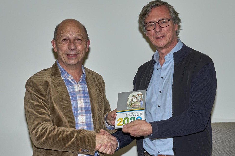 Herman Van Gorp overhandigt het eerste exemplaar van de Groot-Kastelse Volkskalender 2023 aan burgemeester Ward Kennes.