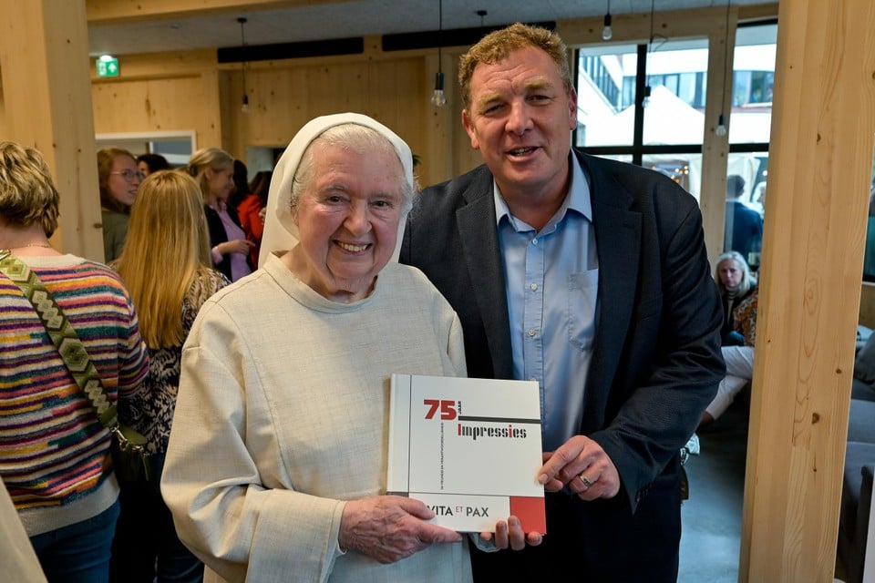 Burgemeester Maarten De Veuster, zelf geen oud-leerling, en z﻿uster-Benedictines Erica met het zopas voorgestelde boek over 75 jaar Vita et Pax-college.