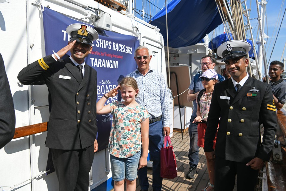 Ellen (8) en haar opa Hugo bij de officieren van het Indische marineschip Tarangini. 