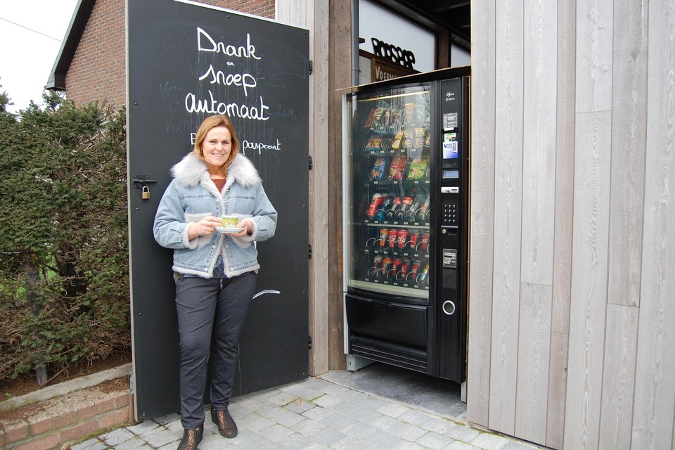 Marleen van café De Voermansrust bij haar gloednieuwe drank- en snoepautomaat.