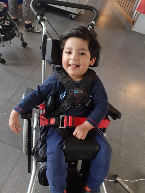 Alexander (3) in zijn op maat gemaakte rolstoel. 