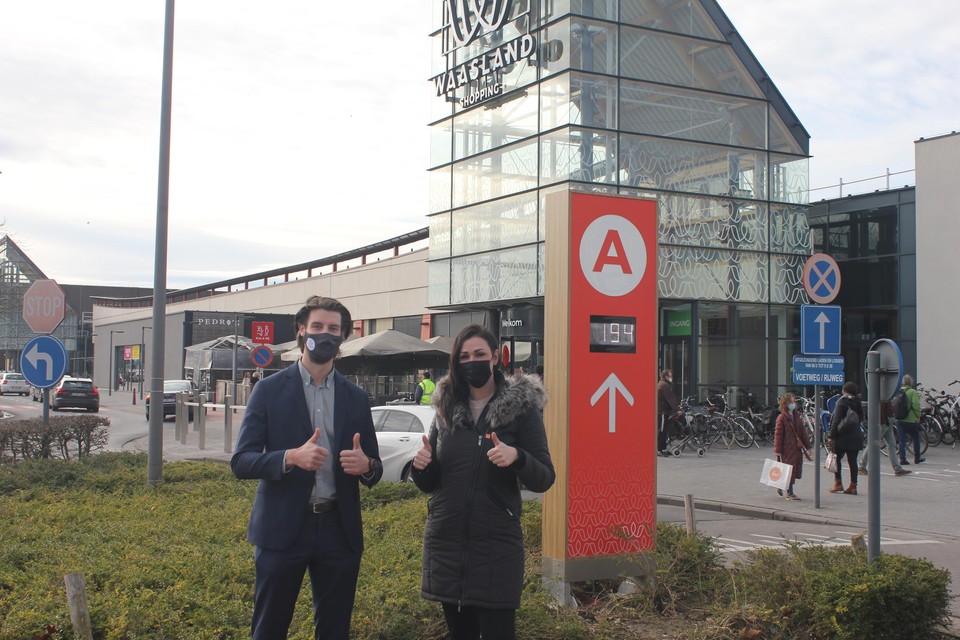 Vincent Hermans en Lesley-Anne Smet aan een digitaal paneel op de parking. Zo kan u ook zonder smartphone zien hoeveel vrije plaatsen er nog zijn.