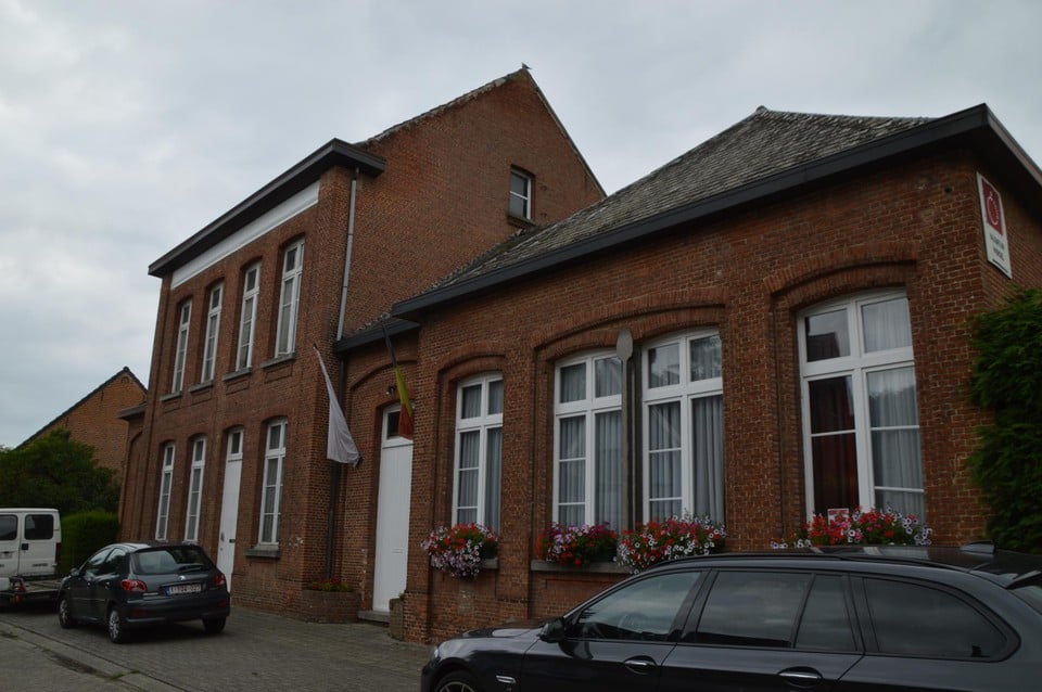 Het oud schoolgebouw met achterliggende chirolokalen.