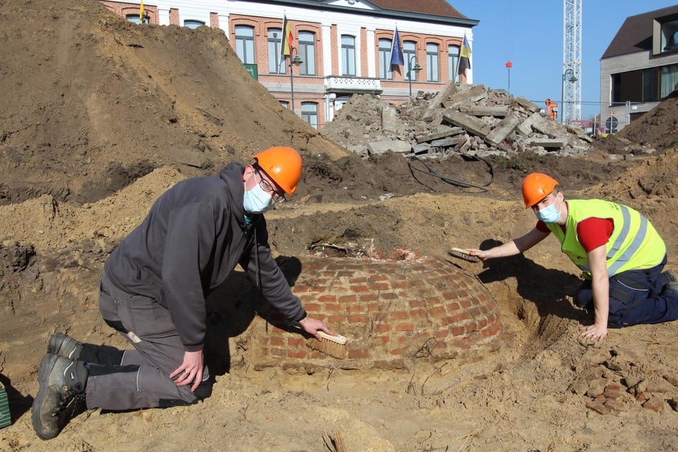 Projectleider Bart en student Dries bij de ontdekte waterput op de markt in Kasterlee.