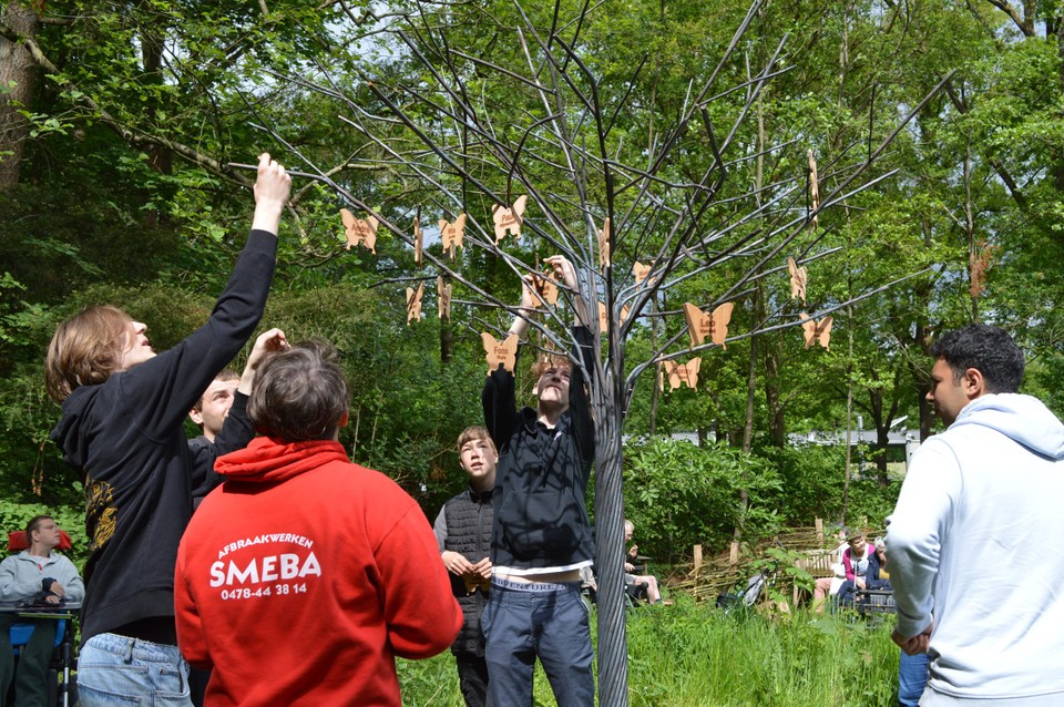 De houten vlinders met de namen van de overledenen worden in de boom gehangen. 