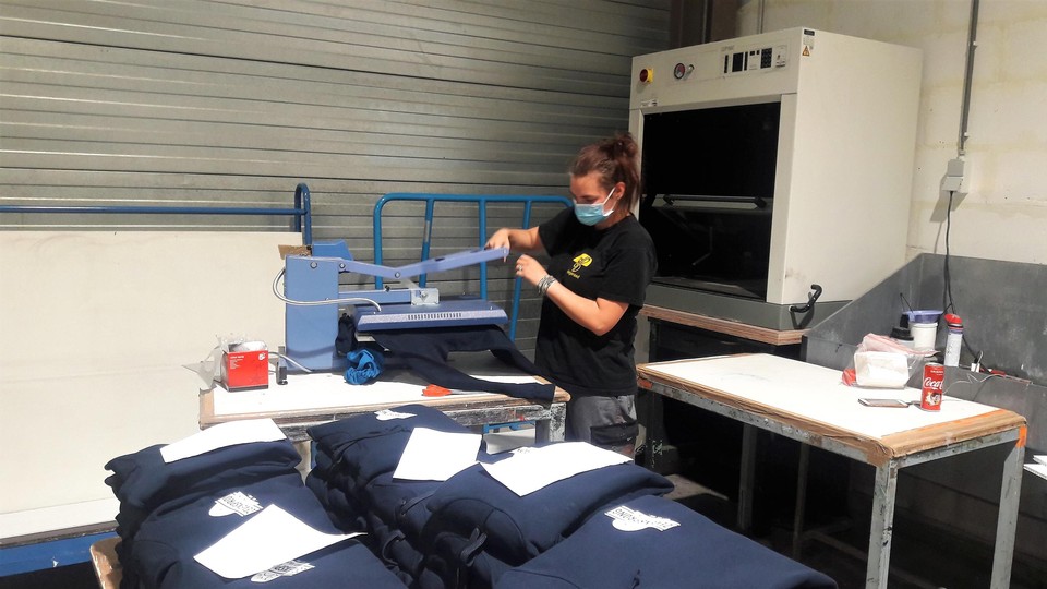 Logo’s worden op T-shirt en sweaters geperst via transferdruk.