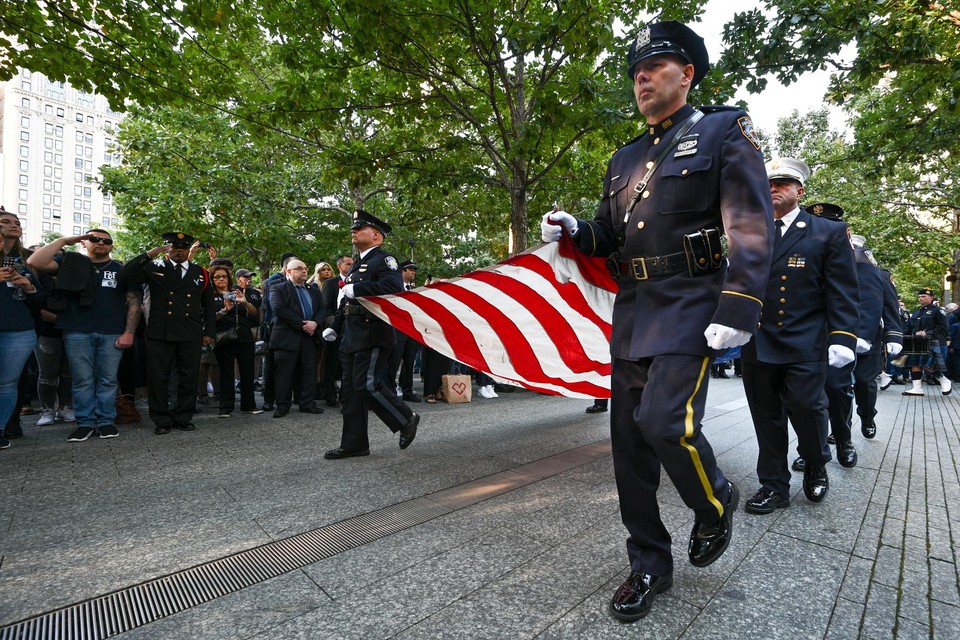 Politiemannen droegen een grote Amerikaanse vlag tijdens de herdenking op Ground Zero in New York. 