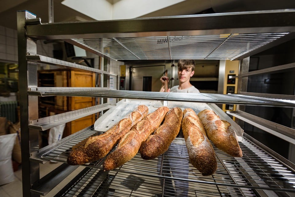 Bakker Viktor Fierens haalt versgebakken stokbroden uit de oven.