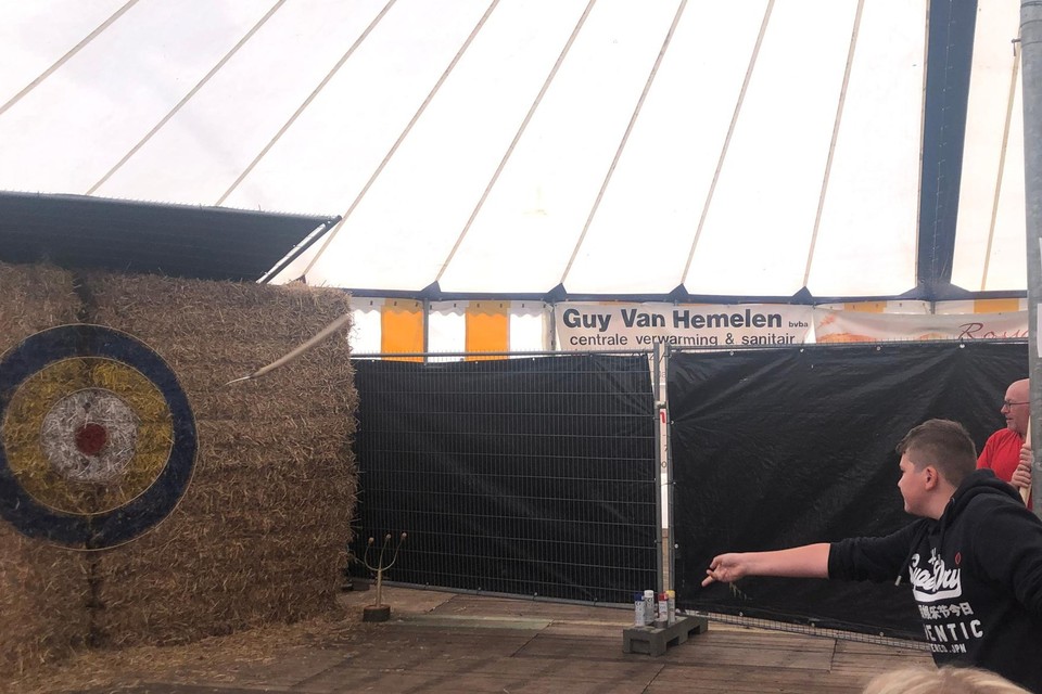 Sem Laenen mikt een riek op een dartsbord in enkele balen hooi op Achterlee kermis in Lichtaart.