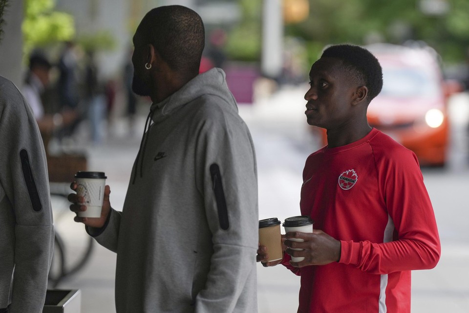 Canadees international Richie Laryea (rechts) is met zijn ploegmaats buiten het hotel een koffie gaan halen tijdens de stakingsactie.