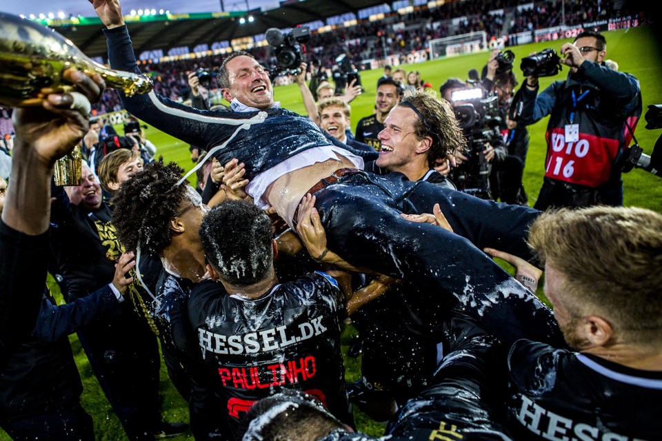 Dion Cools kijkt glimlachend toe hoe Scholz (ex-Lokeren, -Standard en - Club) en andere ploegmaats coach Priske vieren na het behalen van de Deense landstitel. Inzet: Cools juicht na een doelpunt voor Midtjylland. 