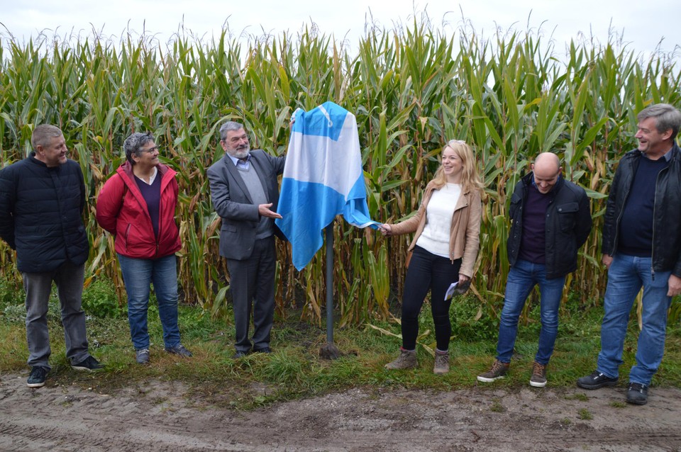 De onthulling van het bord. Eerst ligt er nog de vlag van Malle over gedrapeerd.