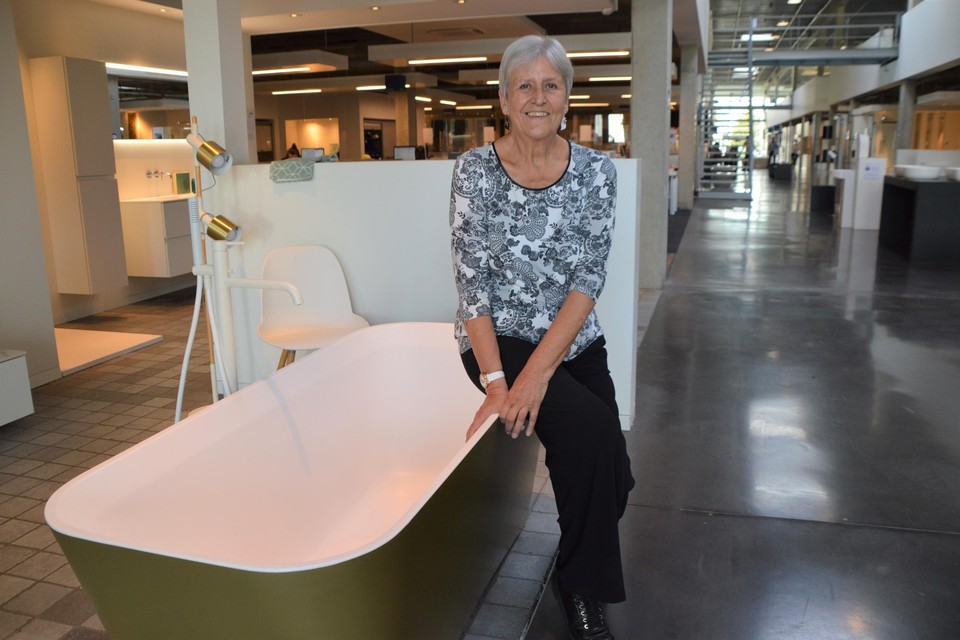 Denise Lamoen als gouden werkneemster met vijftig jaar dienst op een gouden bad in de toonzaal van Desco.