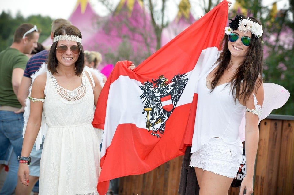 Twee fleurig uitgedoste dames met de vlag van Oostenrijk. 