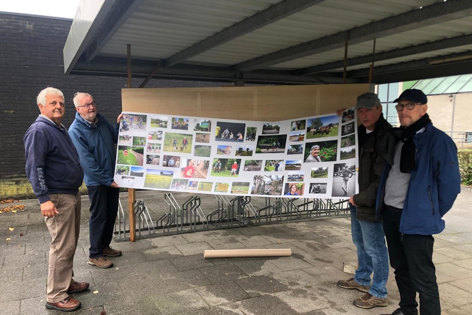 Walter Leysen, Bert Embrechts, Ludo Van den Schoor en Bert Nys van Fotoclub Visueel bevestigen een poster met foto’s van hun project ‘24 uren van Lichtaart’ op een paneel.