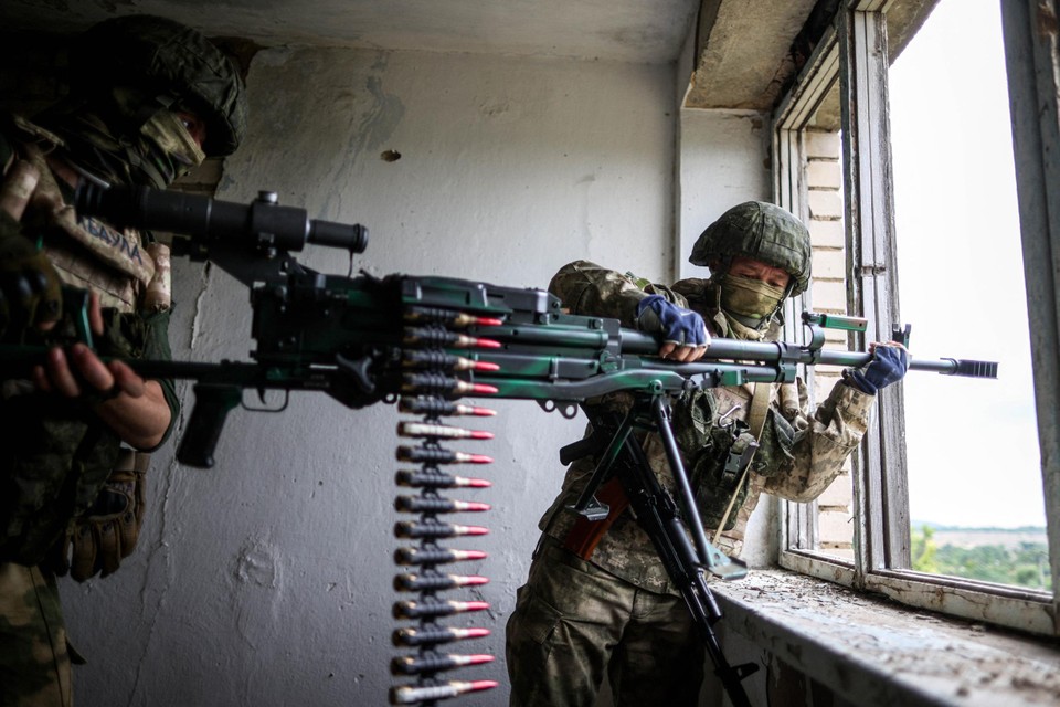 Russische soldaten nemen een positie in op de bovenverdieping van een appartementsgebouw in Cherson in het zuiden van Oekraïne.  