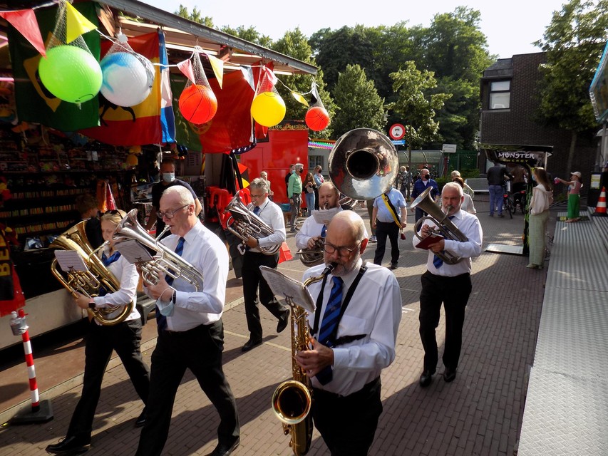 Muzikanten van fanfare De Ware Vrienden stappen langs de kermiskramen in Vosselaar.