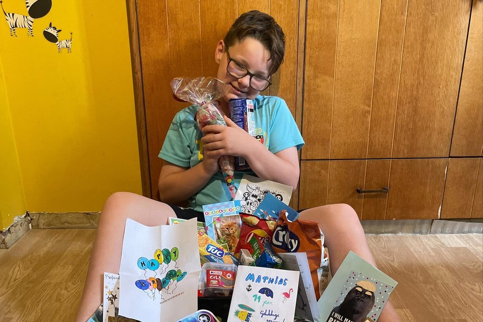 De jarige Mathias met kaartjes, tekeningen, snoepgoed en cadeautjes die hij kreeg na een oproep van zijn mama.