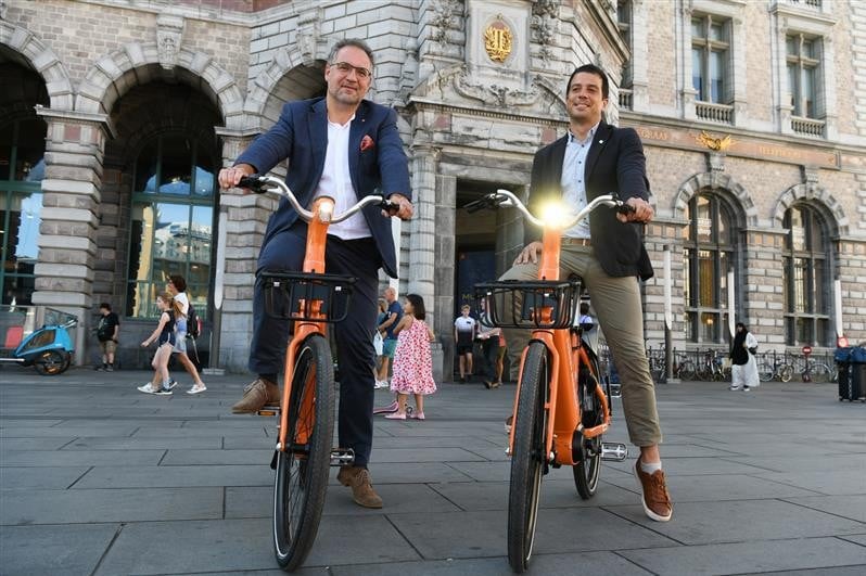 Koen Kennis, schepen en voorzitter van de Antwerpse vervoerregio, en Erdem Ovacik, CEO van Donkey Republic, rollen de elektrische deelfietsen uit in Antwerpen. 