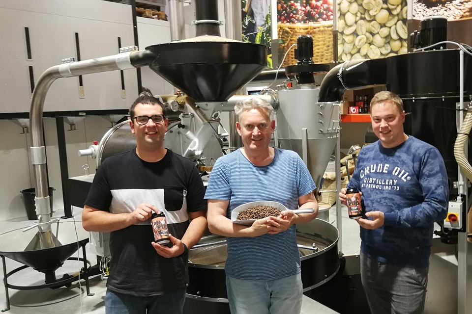 Kim Valgaeren (links) en Stijn Aerts (rechts) van brouwerij Hoppug tonen hun koffiestout Zjatteke Kaffe die ze creëerden met hulp van de koffiekenners Wim Janssens (midden) en Jef Seykens (afwezig) van koffiebranderij Mokapi. 