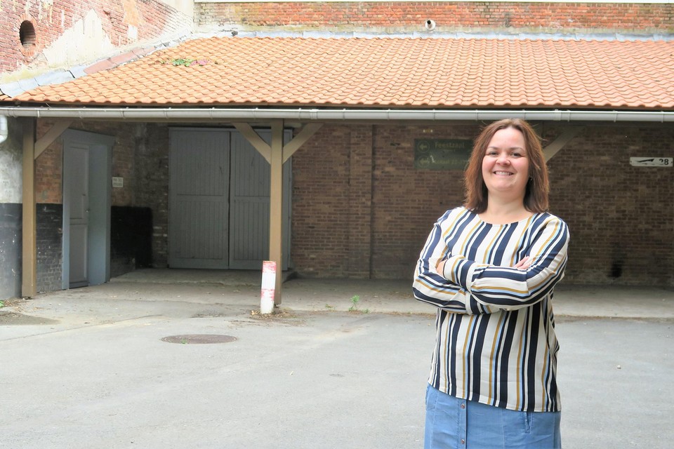 Schepen Ann Theys voor de overkapping die toegang geeft tot de feestzaal en die even bedreigd leek. “Ze mag gelukkig blijven staan zolang ze in gebruik is.”