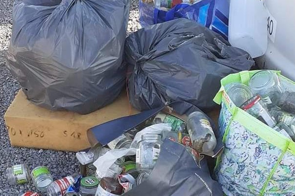Een sluikstort met gedumpte vuilzakken.