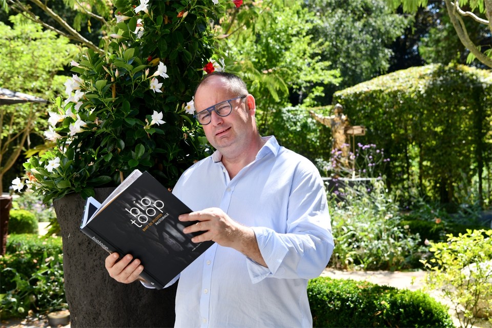 Bart De Pooter met zijn boek Biotoop in zijn eigen biotoop, de tuin van zijn restaurant Pastorale. 