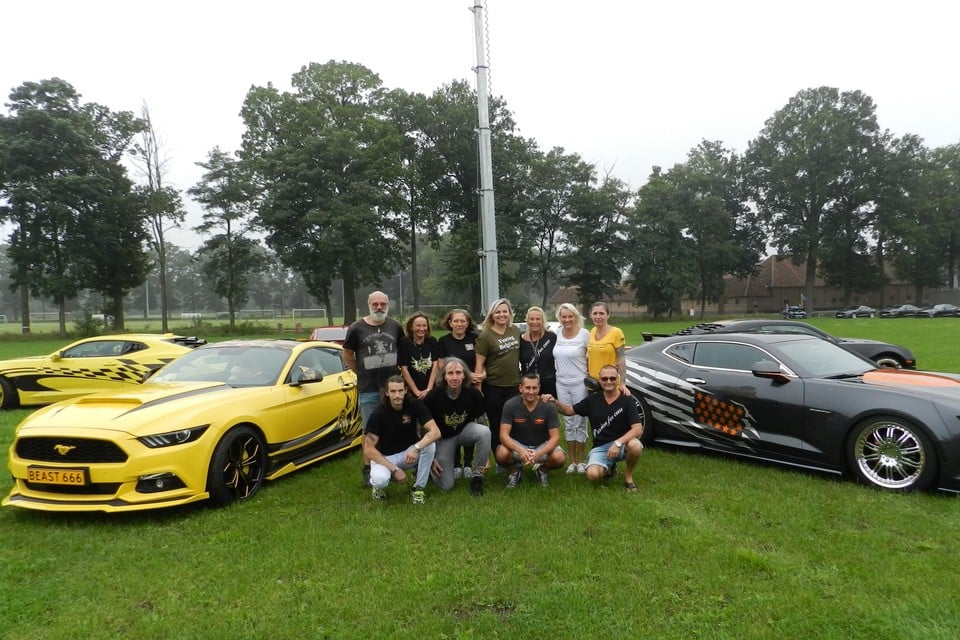 Enkele leden van vzw Passion for Cars tussen enkele wagens van het merk Camaro.