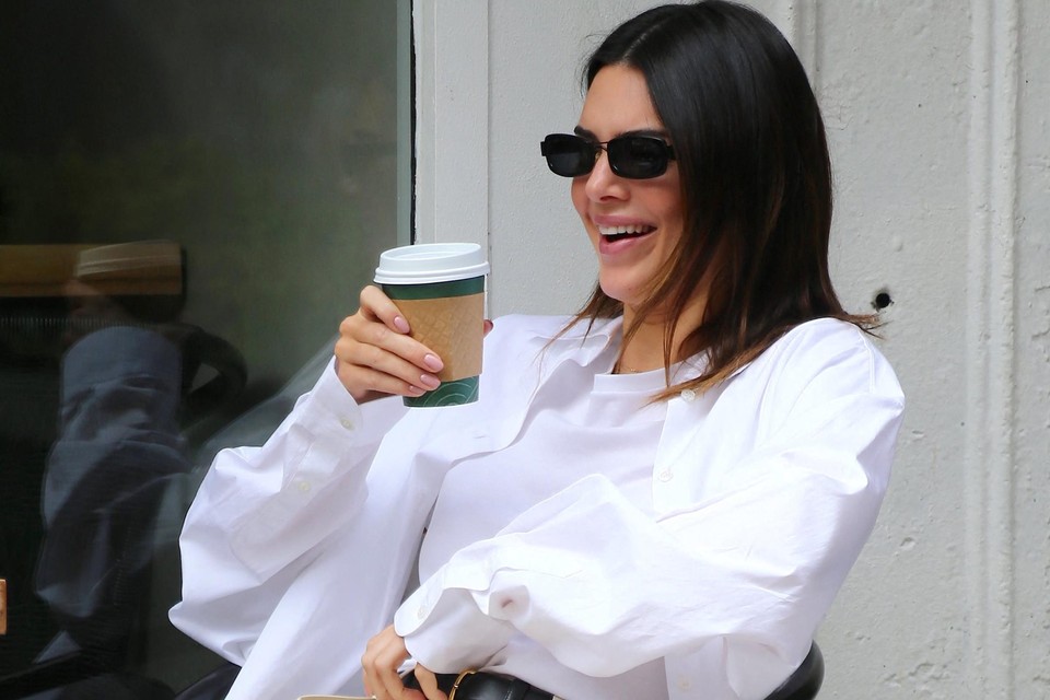 Kendall Jenner, met zonnebril op de neus, geniet van een terrasje met een koffie.