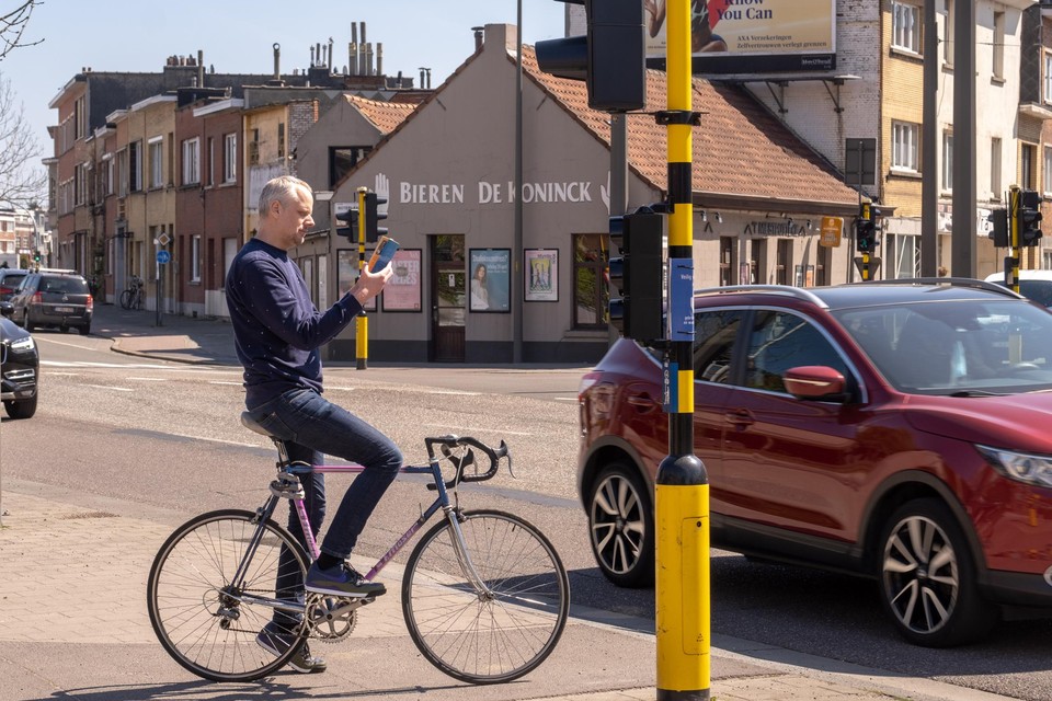 Wouter Berteloot, voorzitter van de Fietsersbond Deurne, leest een boek terwijl hij wacht en wacht op groen licht.