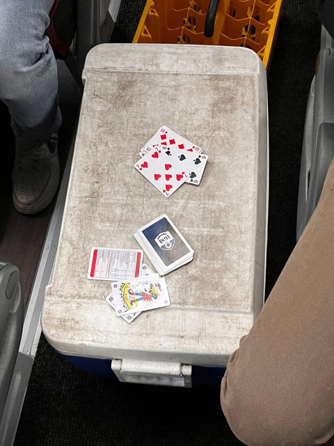 Tijdens de busrit spelen enkele supporters een kaartspelletje. 