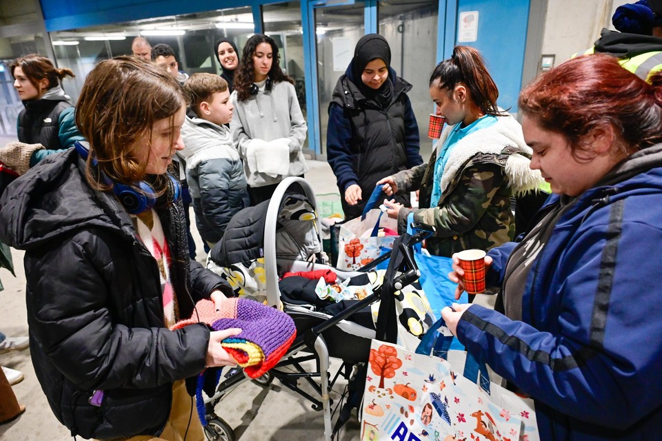 Jongeren van De Wereld van Rayaan delen mutsen en sjaals uit die ze samen met de bewoners van Sint-Maria hebben gebreid voor daklozen.